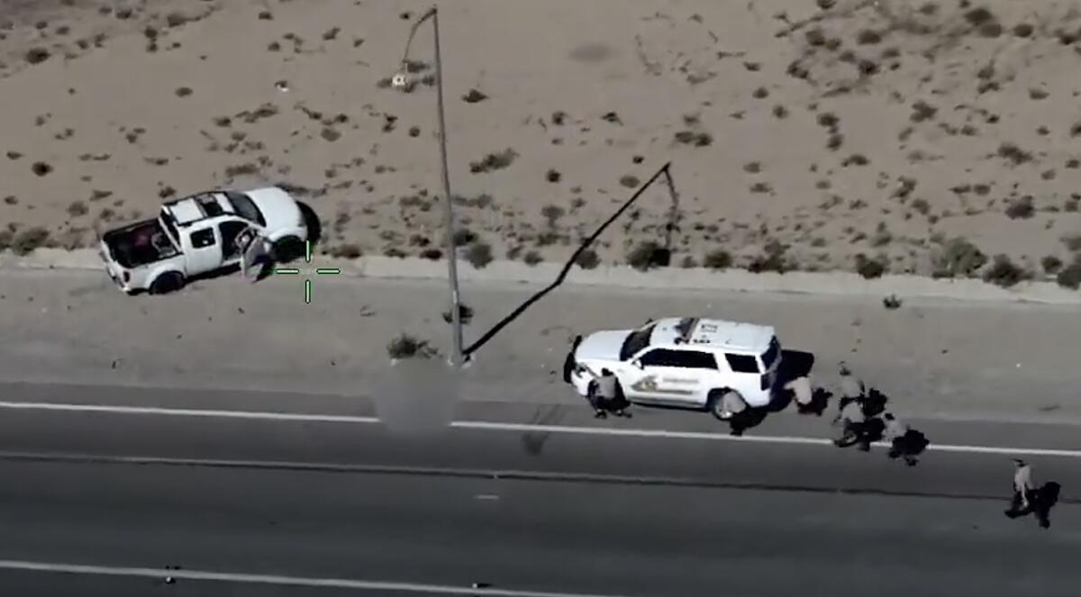 An image from a video showing a white truck, left, and a white police vehicle