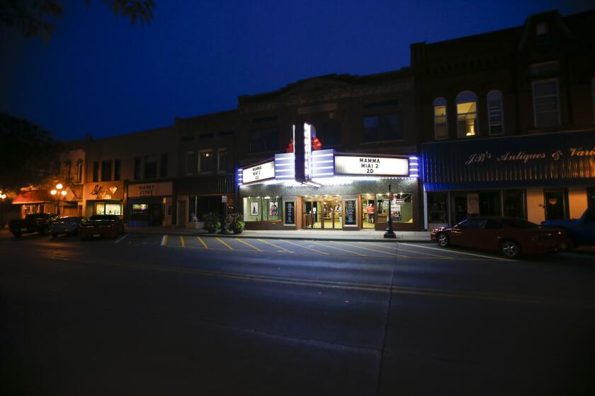 The marquee is lighted up for the 7 p.m. showing of "Mamma Mia 2" at the Webster Theater in Webster City, Iowa. The theater, with its 206 marquee bulbs and $4 tickets, is a central character in a story that balances tradition against the tug and pressures of today.