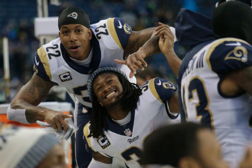 Los Angeles Rams players Trumaine Johnson (22) and Todd Gurley (30) celebrate on the bench during the second half of an NFL football game against the Seattle Seahawks, Sunday, Dec. 17, 2017, in Seattle. The Rams won 42-7. (AP Photo/John Froschauer)