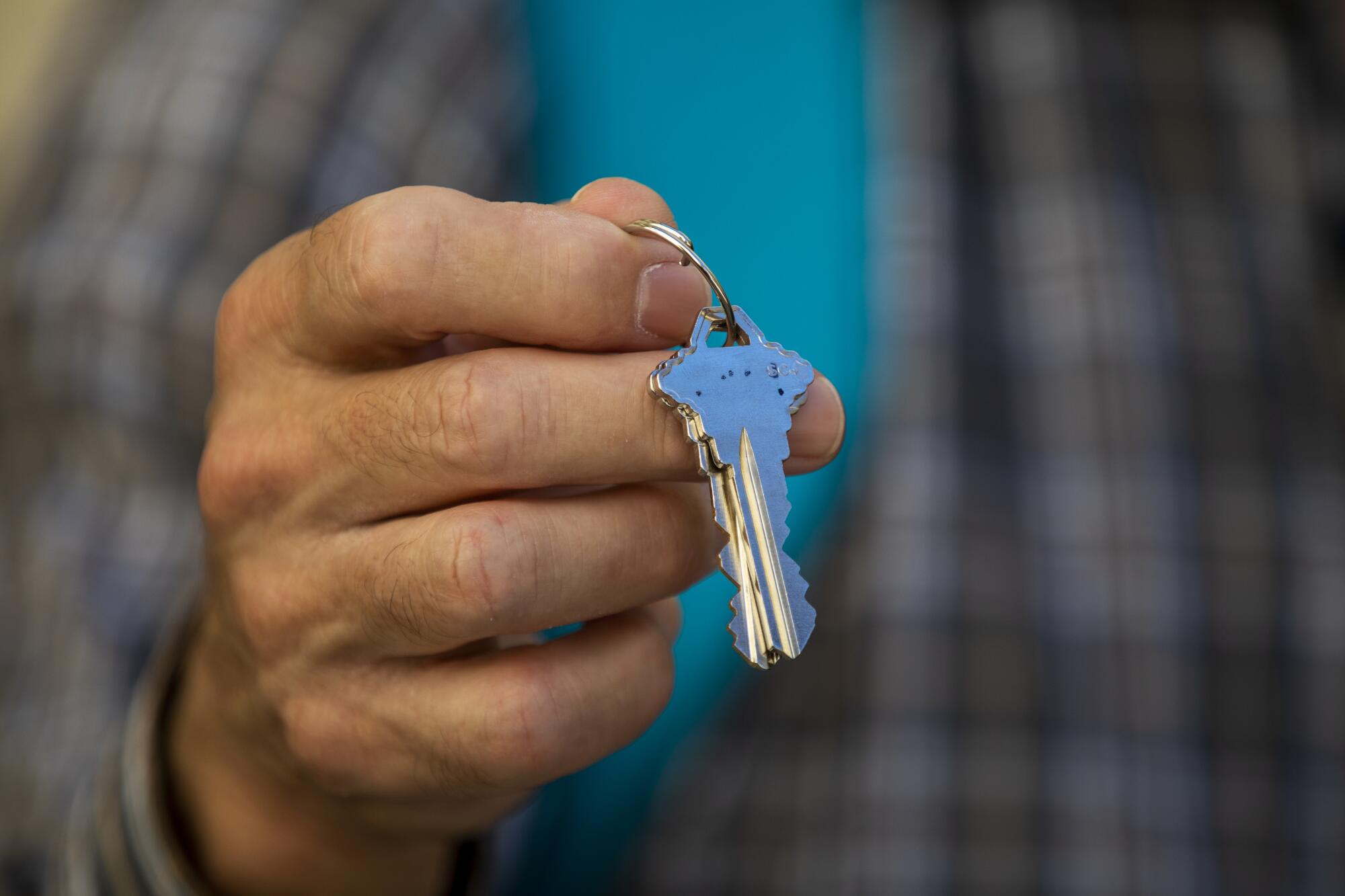 A man holds the keys to his new home at Washington View Apartments in Los Angeles.