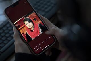 A woman looks at a picture of former Afghan lawmaker Mursal Nabizada on her mobile phone