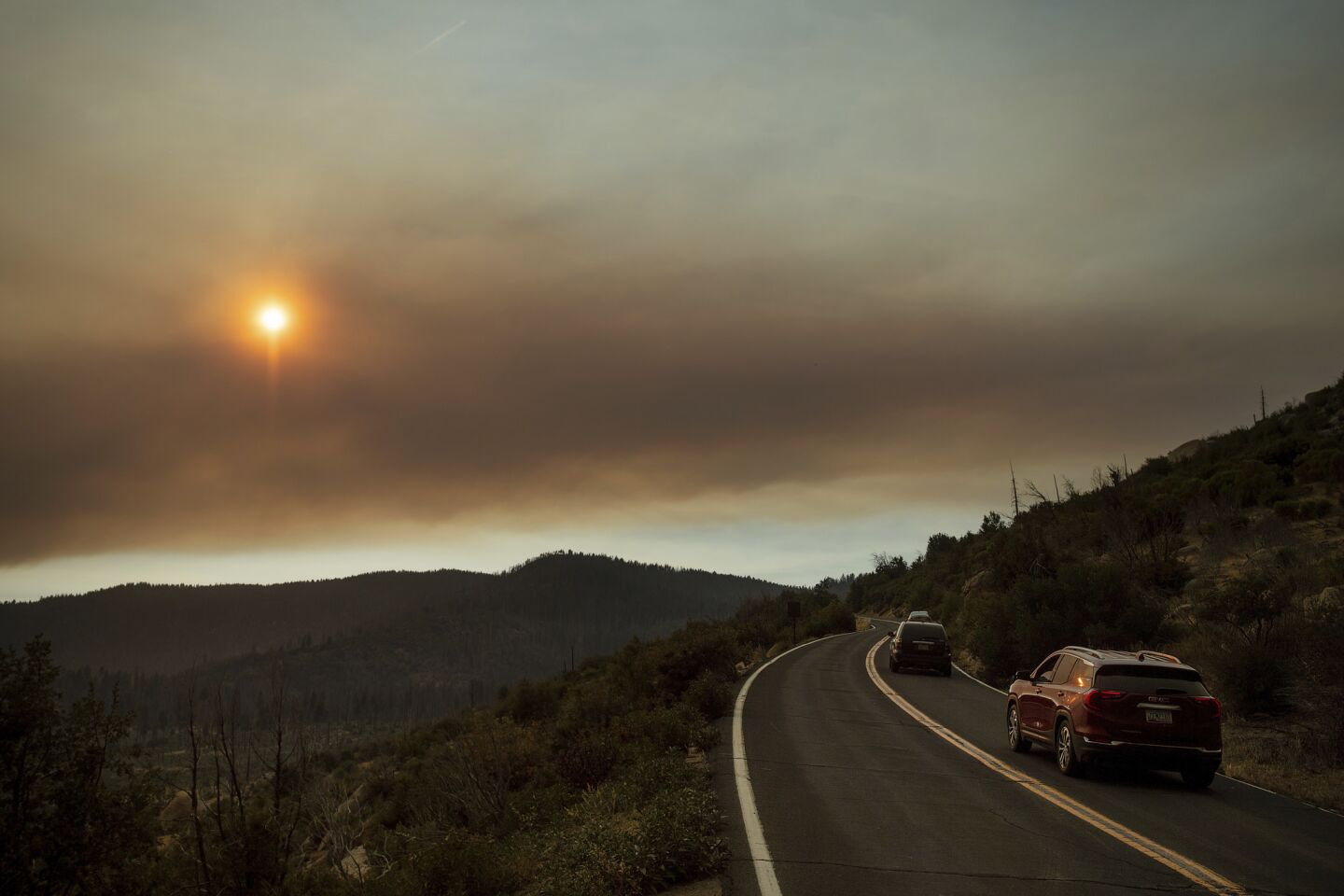 As smoke from the Ferguson fire fills the sky, vehicles leave Yosemite Valley in Yosemite National Park.