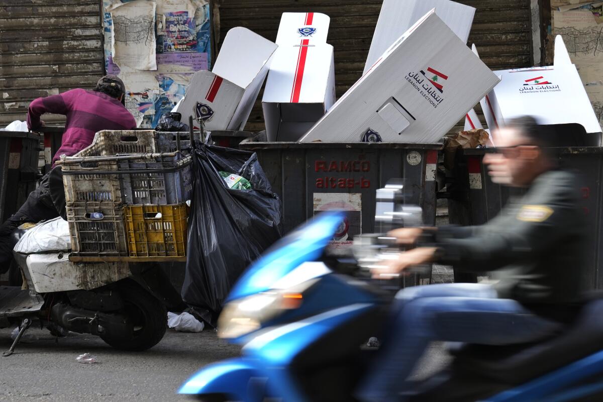 Man searching through a dumpster for recyclable items in Beirut
