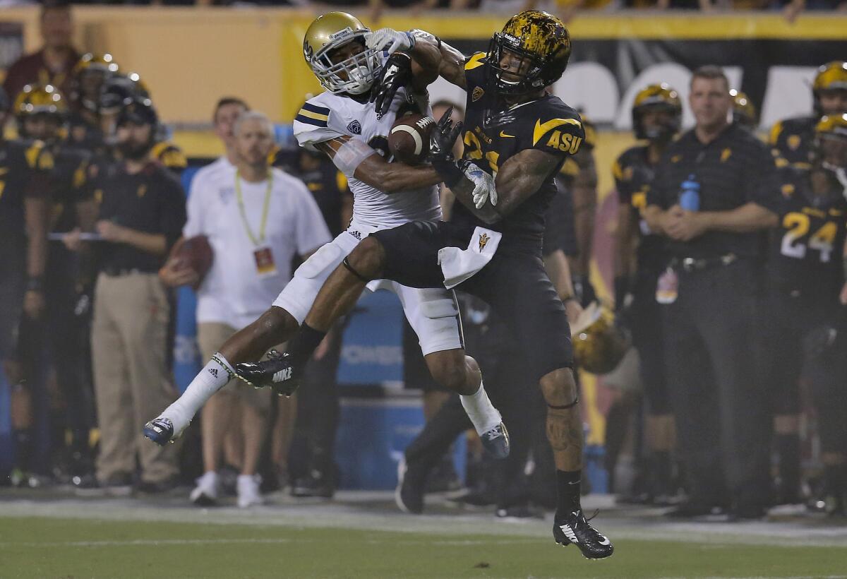 UCLA defensive back Anthony Jefferson, left, intercepts a pass intended for Arizona State wide receiver Jaelen Strong during a Sept. 25 game.