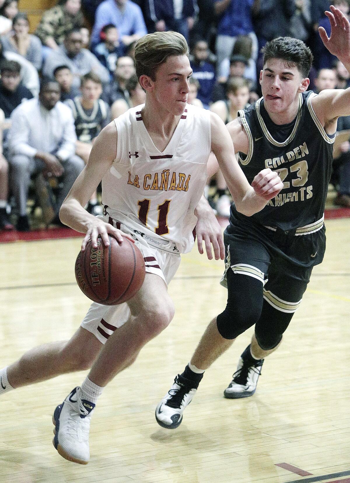 La Canada's Jacob Nussbaum drives against St. Francis' Jason Gallant in CIF Southern Section Division II-A first-round boys' basketball playoff at La Canada High School on Wednesday, February 12, 2020.