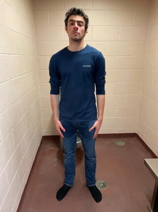 Luigi Mangione stands in a small holding cell
