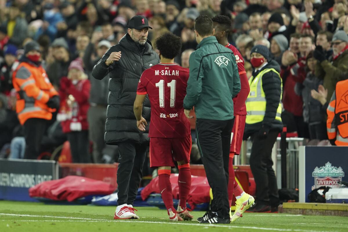 Liverpool's manager Jurgen Klopp, left, greets Liverpool's Mohamed Salah after he is substituted during the Champions League group B soccer match between Liverpool and FC Porto at Anfield stadium in Liverpool, Wednesday, Nov. 24, 2021. (AP Photo/Jon Super)