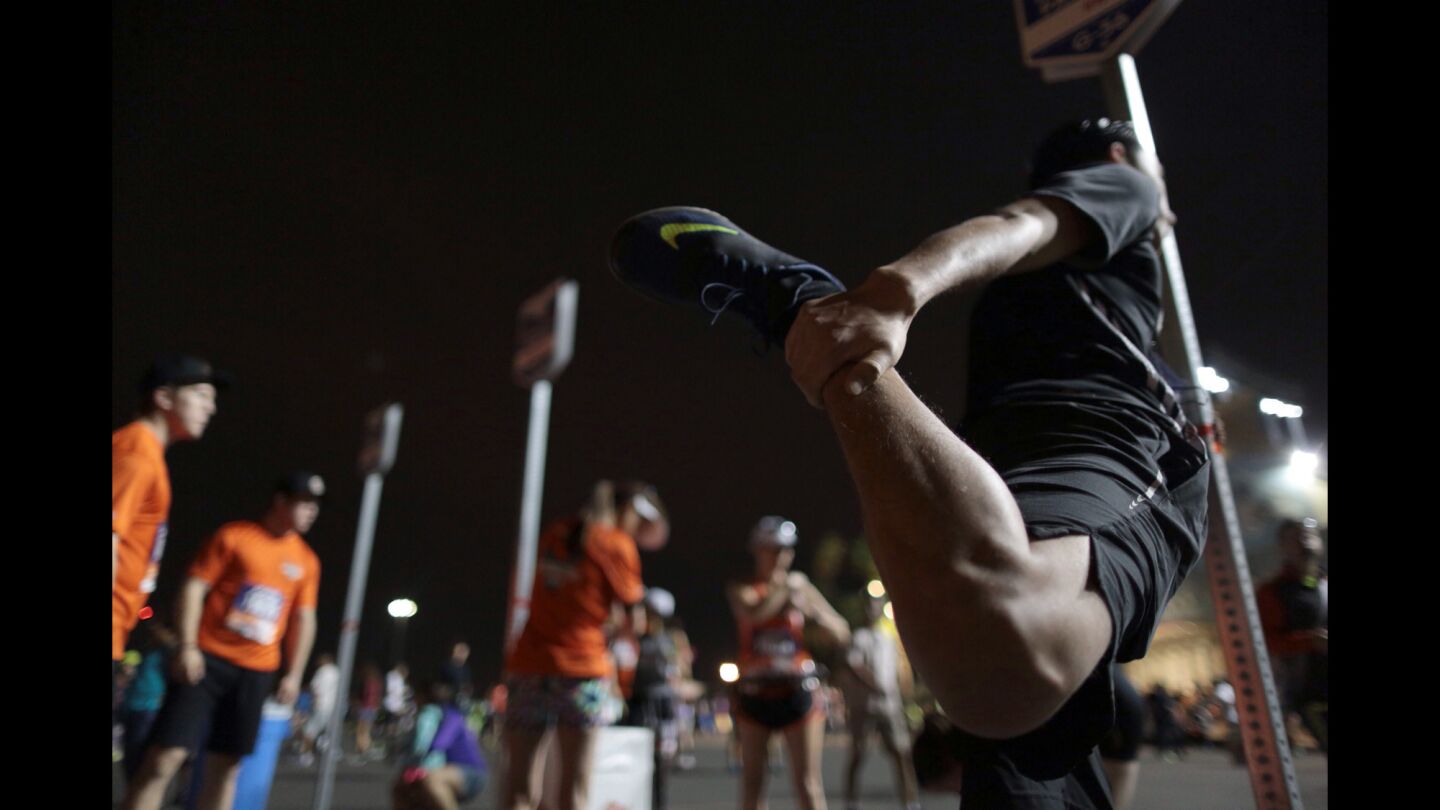 A runner stretches at the start of the 30th Los Angeles Marathon at Dodger Stadium on Sunday morning.
