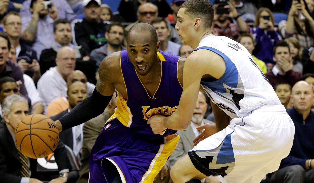 Lakers guard Kobe Bryant drives the baseline against Timberwolves guard Zach LaVine in the first half.
