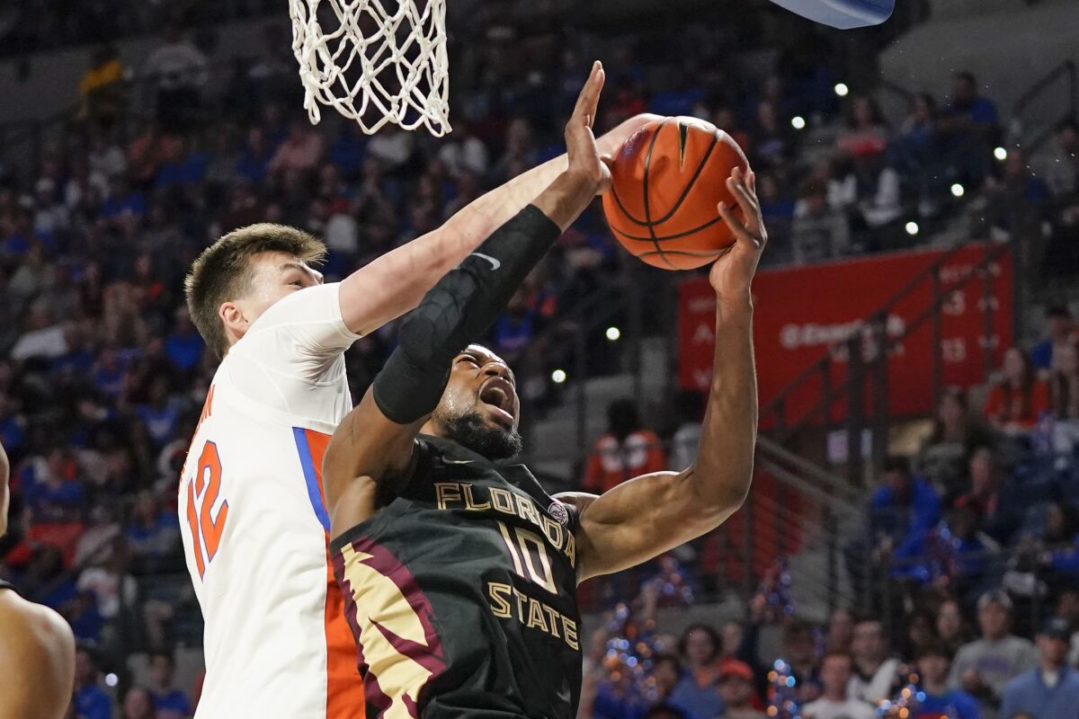 Florida forward Colin Castleton, left, blocks a shot attempt by Florida State forward Malik Osborne (10) during the first half of an NCAA college basketball game, Sunday, Nov. 14, 2021, in Gainesville, Fla. (AP Photo/John Raoux)