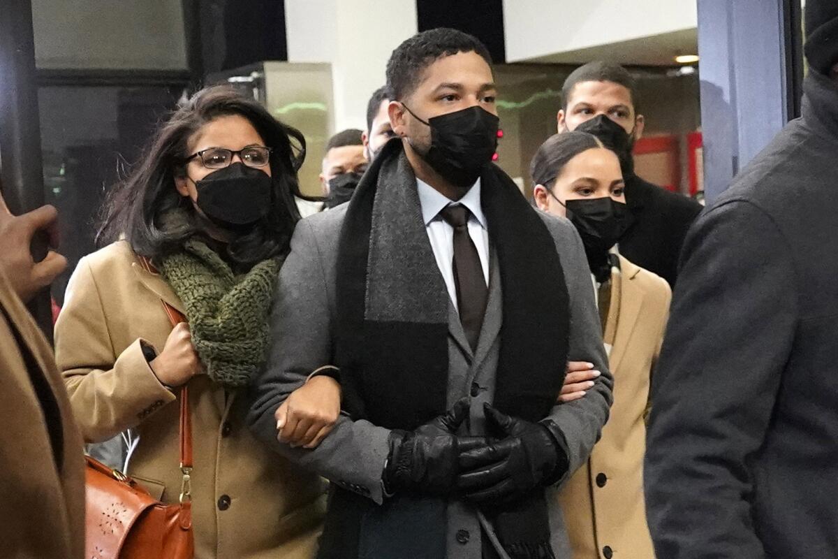 Actor Jussie Smollett grasps arms with family members.