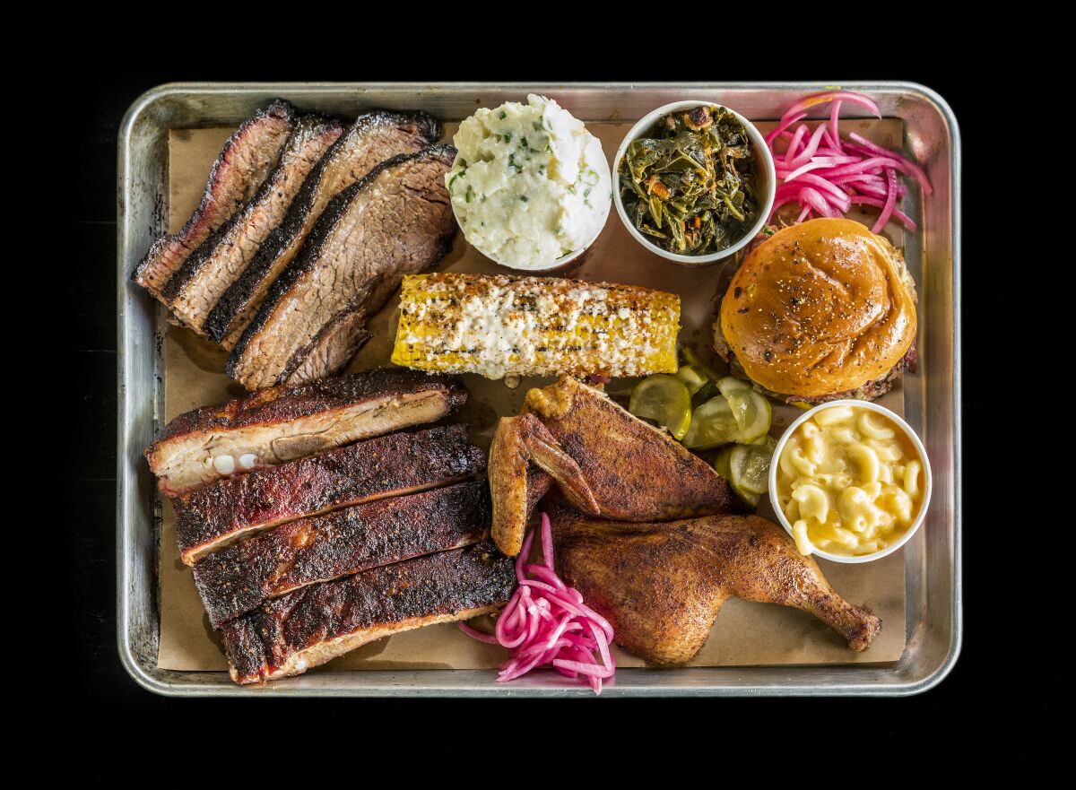 Platter of brisket, spare ribs, smoked chicken, collards, mac and cheese, corn on the cob and potato salad from Slab Barbecue