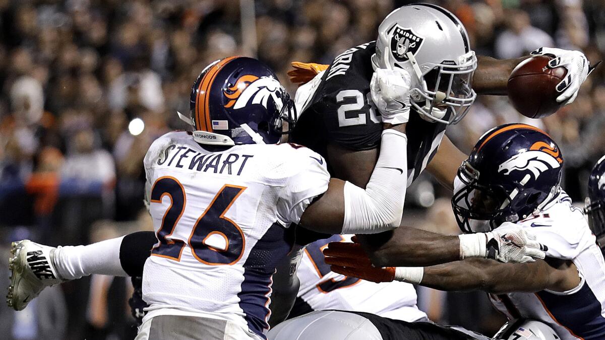 Raiders running back Latavius Murray dives for a touchdown against the Broncos during the second half Sunday.