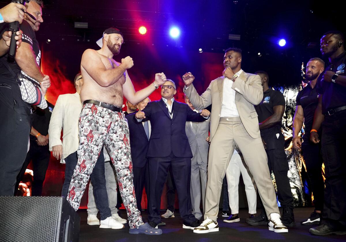 Tyson Fury, left, and Francis Ngannou during a p 