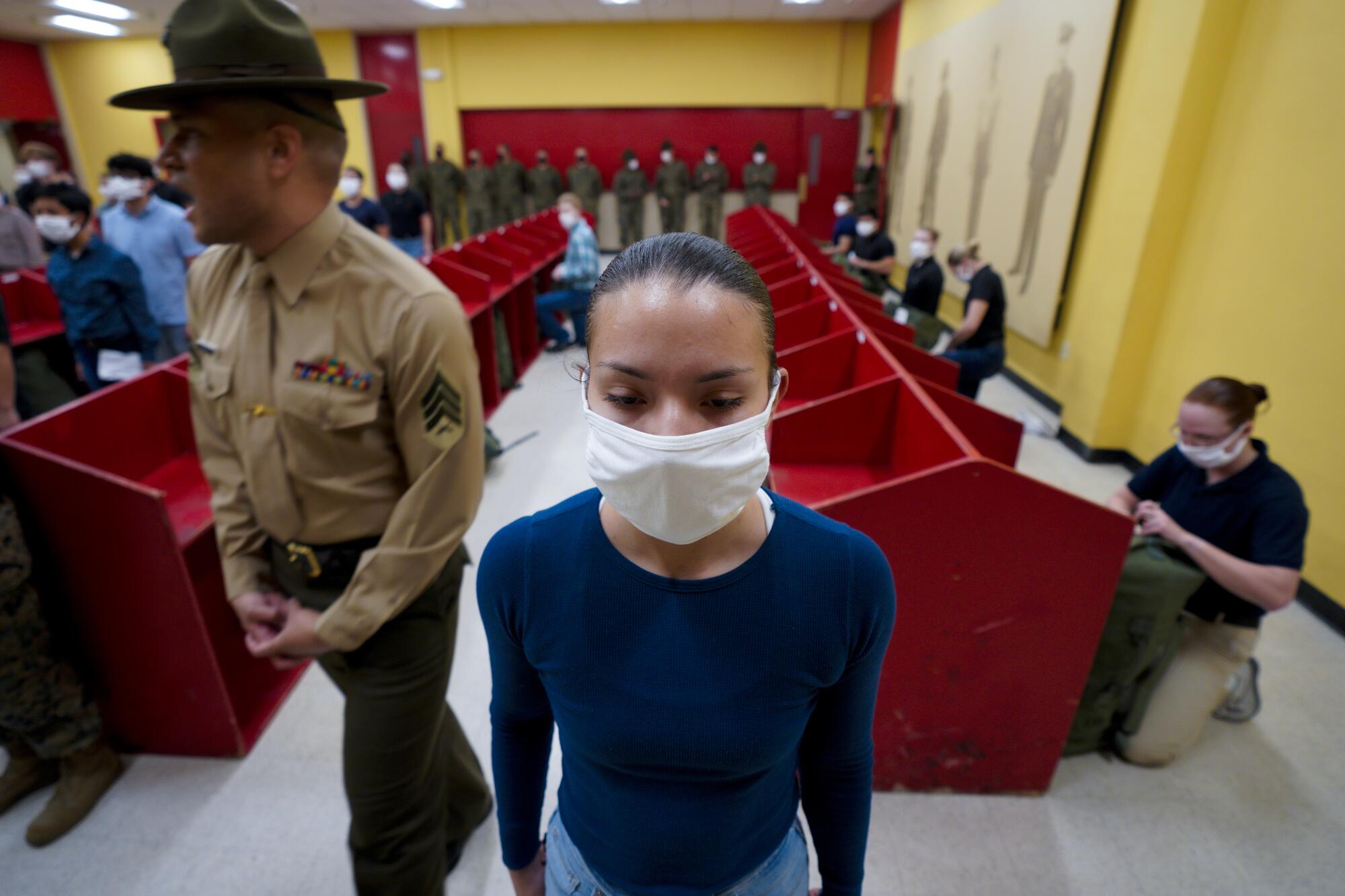 A female Marine recruit stands at attention