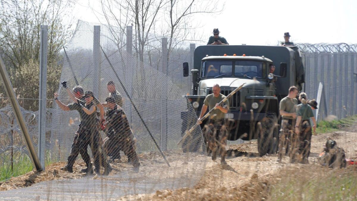 In this April 2016 photo, Hungarian soldiers build a temporary protective fence on the border with Serbia near Kelebia, southeast of Budapest. Hungary has begun building a second fence, a government spokesman confirmed on Feb. 27, 2017.
