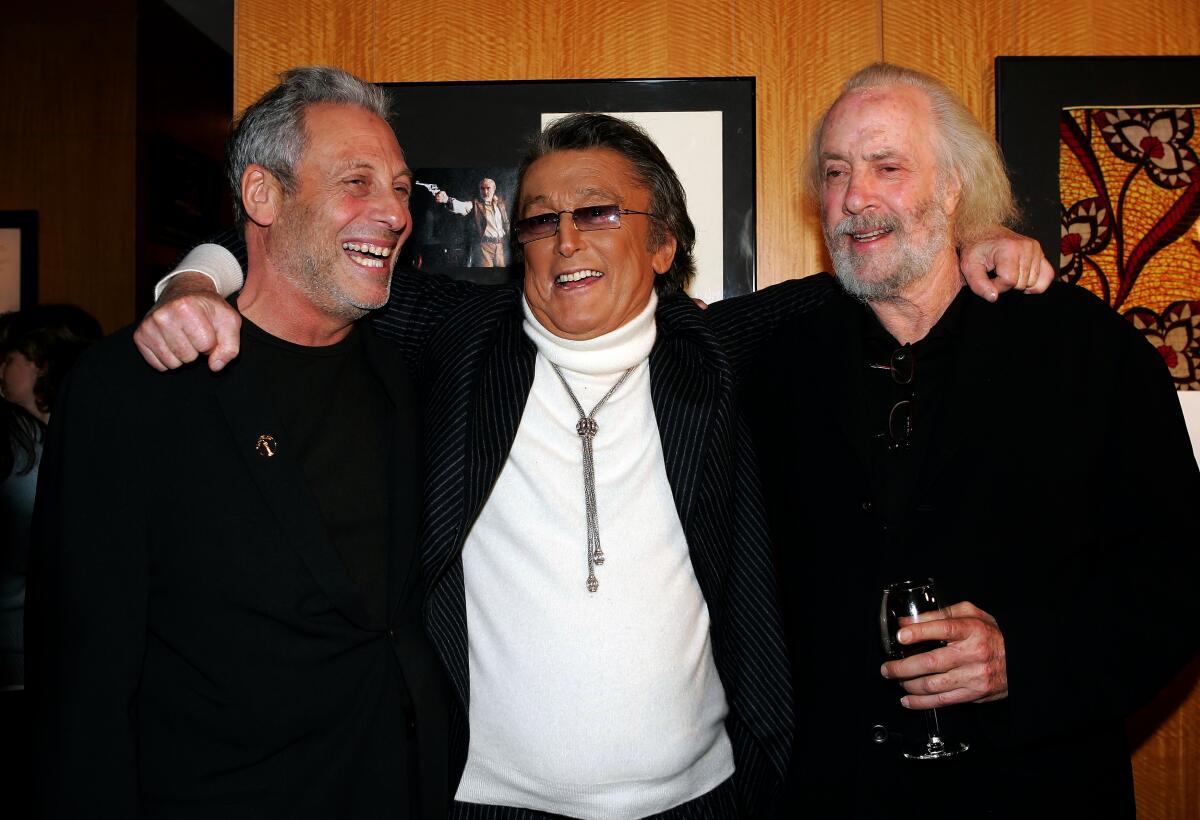 Robert Evans, center, puts his arms around Hawk Koch and Robert Towne as they all laugh.