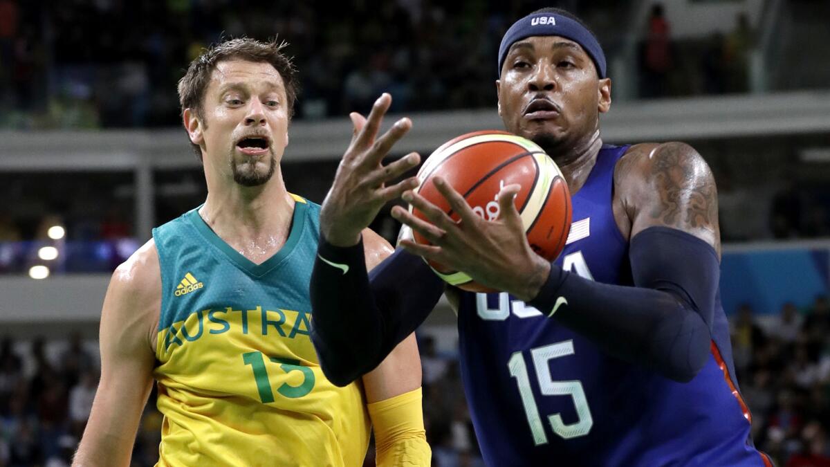 U.S. forward Carmelo Anthony tries to maintain possession of the ball as he drives past Australia's David Andersen during their preliminary round game on Wednesday.