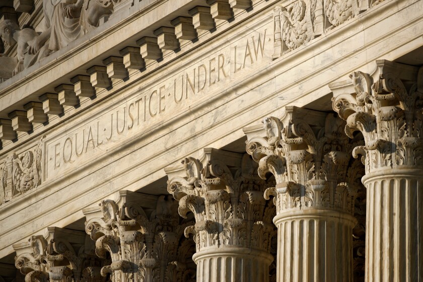 In this May 3, 2020 photo, the setting sun shines on the Supreme Court building on Capitol Hill in Washington.