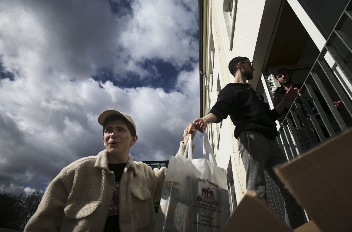 Three refugees from Ukraine help deliver food to people during Passover preparations in Germany.