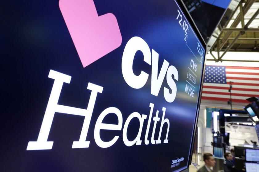 The CVS Health logo appears above a trading post on the floor of the New York Stock Exchange, Monday, Dec. 4, 2017. Drugstore operator CVS is making a $69 billion offer for insurer Aetna as it tries to position itself as a one-stop shop for Americans' health care needs with prescription drugs, clinics and insurance plans to cover those goods and services. (AP Photo/Richard Drew)