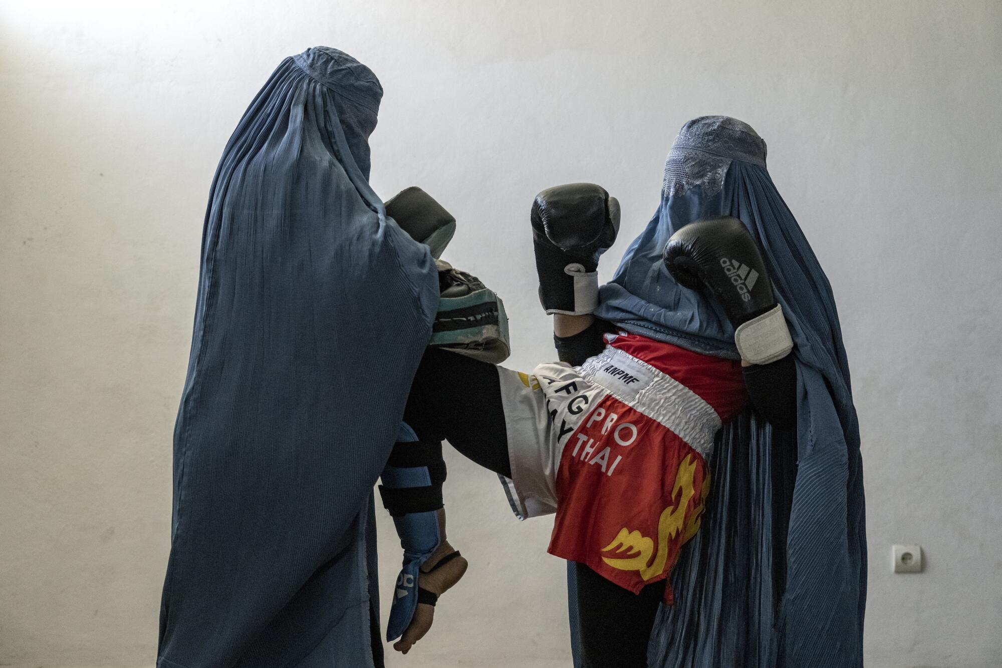Afghan women box while wearing burqas.