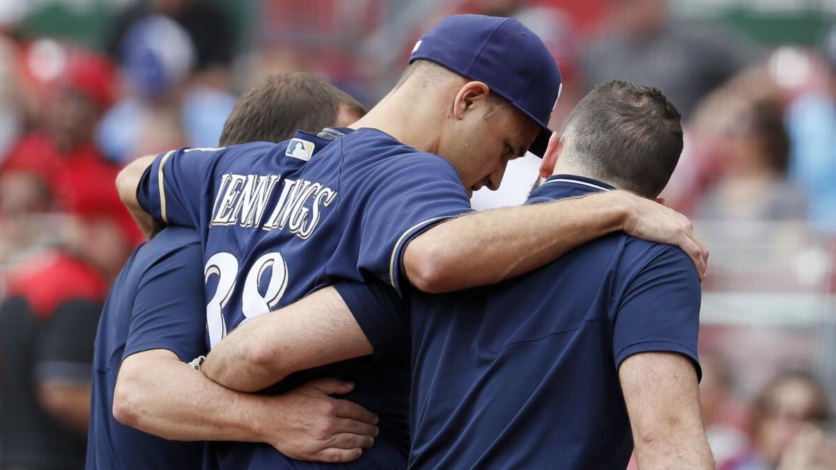 Milwaukee Brewers relief pitcher Dan Jennings is helped off the field after suffering an injury against the Cincinnati Reds on Aug. 30.