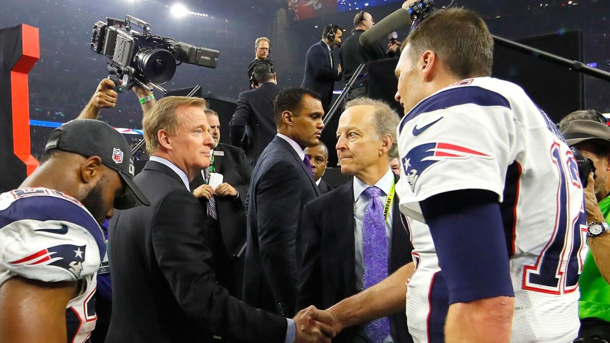 NFL Commissioner Roger Goodell, left, shakes hands with New England quarterback Tom Brady in front of broadcaster Jim Gray, center.