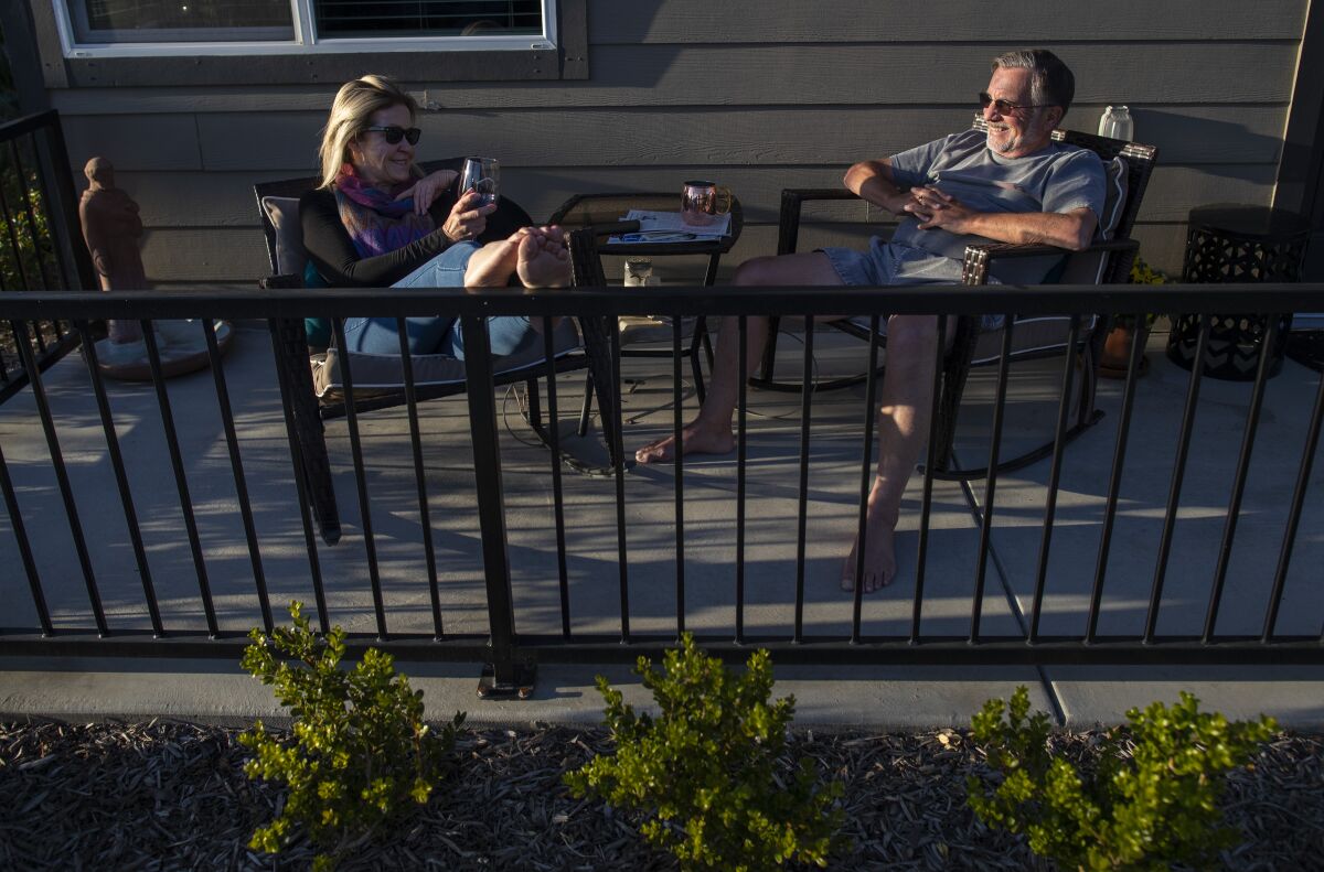 Bree McDowel, left, and Bill Van Heusen, right, enjoy the sunset from their patio at The Row in Fresno.
