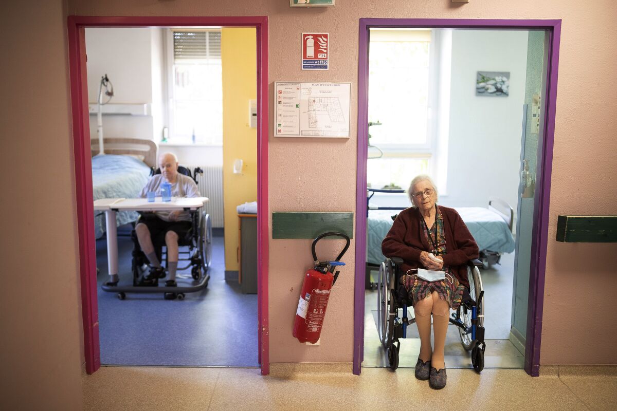 Two nursing home residents sit looking out of their rooms in Ammerschwir, France. The elderly make up a disproportional share of coronavirus victims globally, and that is especially true in nursing homes. Below, a geriatrician shares his plan for reducing the spread of the coronavirus among the elderly.
