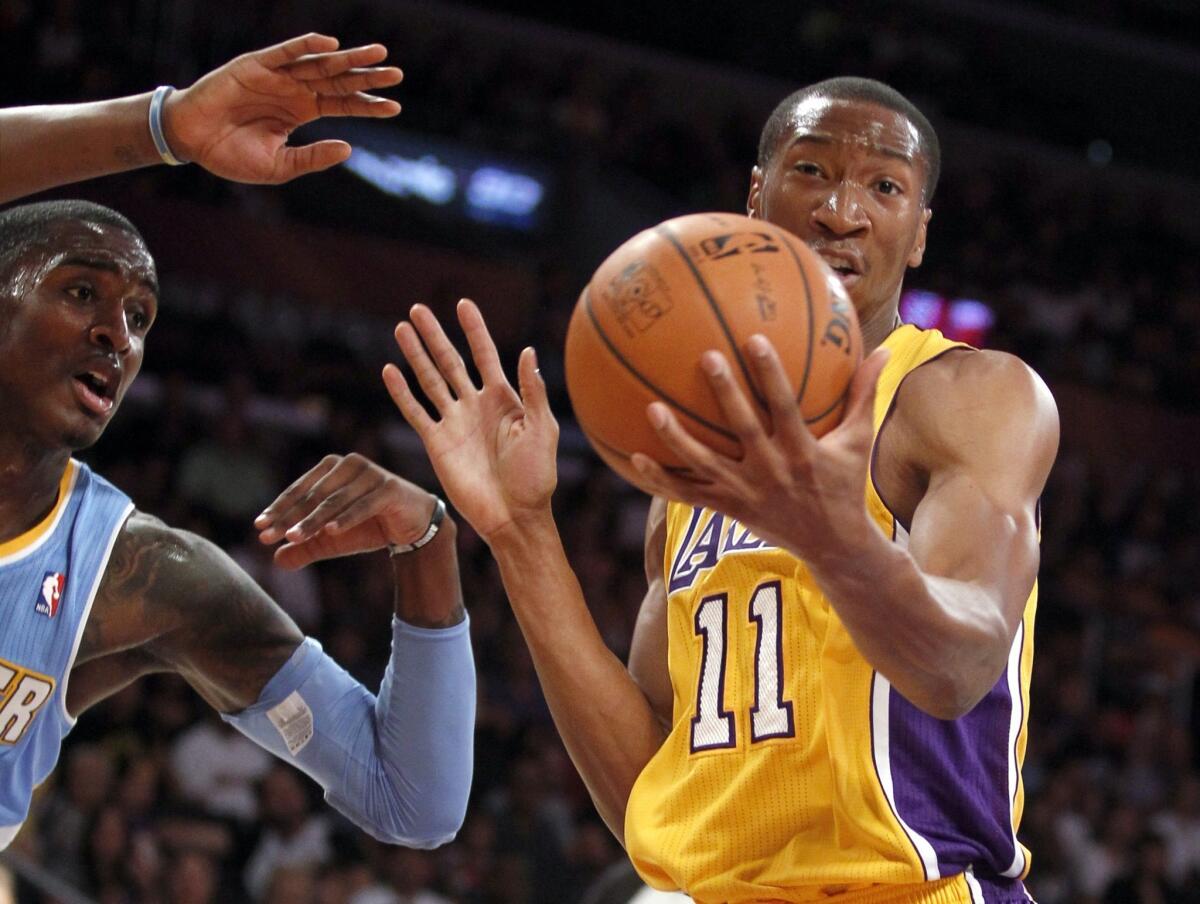 The Lakers' Wesley Johnson pulls down a rebound against Denver Nuggets forward Quincy Miller in the first quarter of Sunday's preseason game.