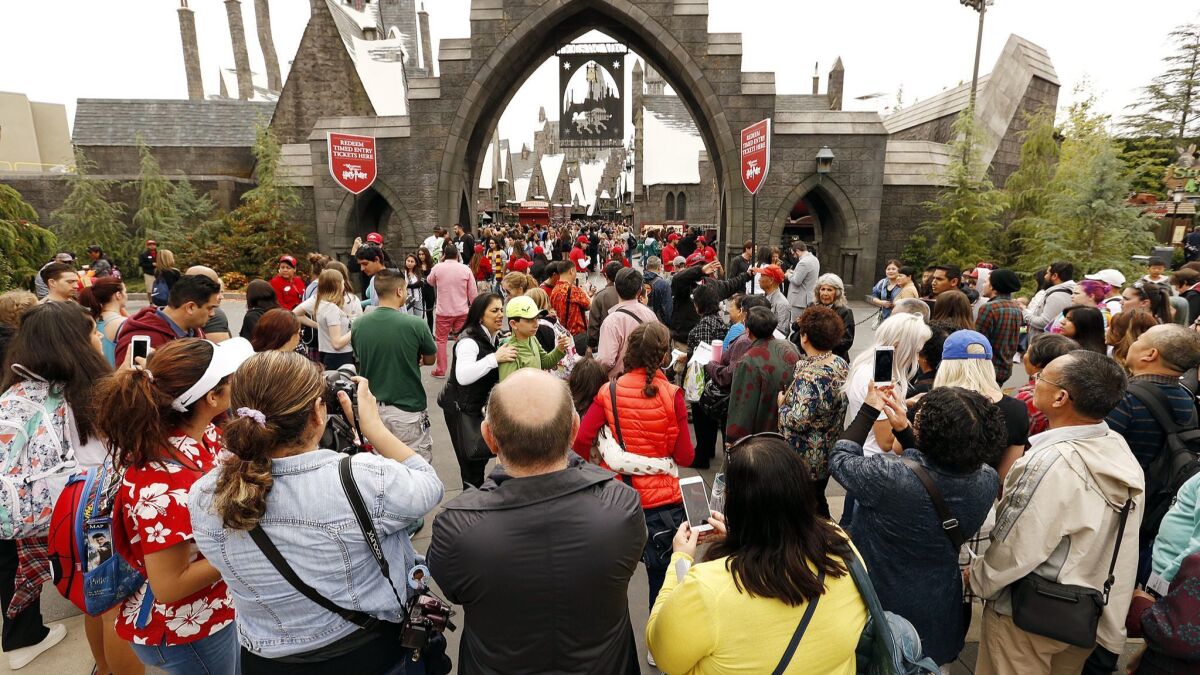 Guests at Universal Studios Hollywood look into the front gate to the Wizarding World of Harry Potter attraction that opened in April 2016.