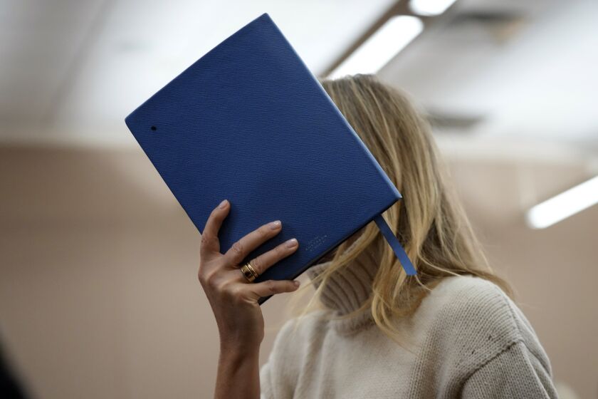 AActor Gwyneth Paltrow shields her face with a blue notebook as she exits a courtroom, Tuesday, March 21, 2023, in Park City, Utah, where she is accused in a lawsuit of crashing into a skier during a 2016 family ski vacation, leaving him with brain damage and four broken ribs. Terry Sanderson claims that the actor-turned-lifestyle influencer was cruising down the slopes so recklessly that they violently collided, leaving him on the ground as she and her entourage continued their descent down Deer Valley Resort, a skiers-only mountain known for its groomed runs, après-ski champagne yurts and posh clientele. (AP Photo/Rick Bowmer, Pool)