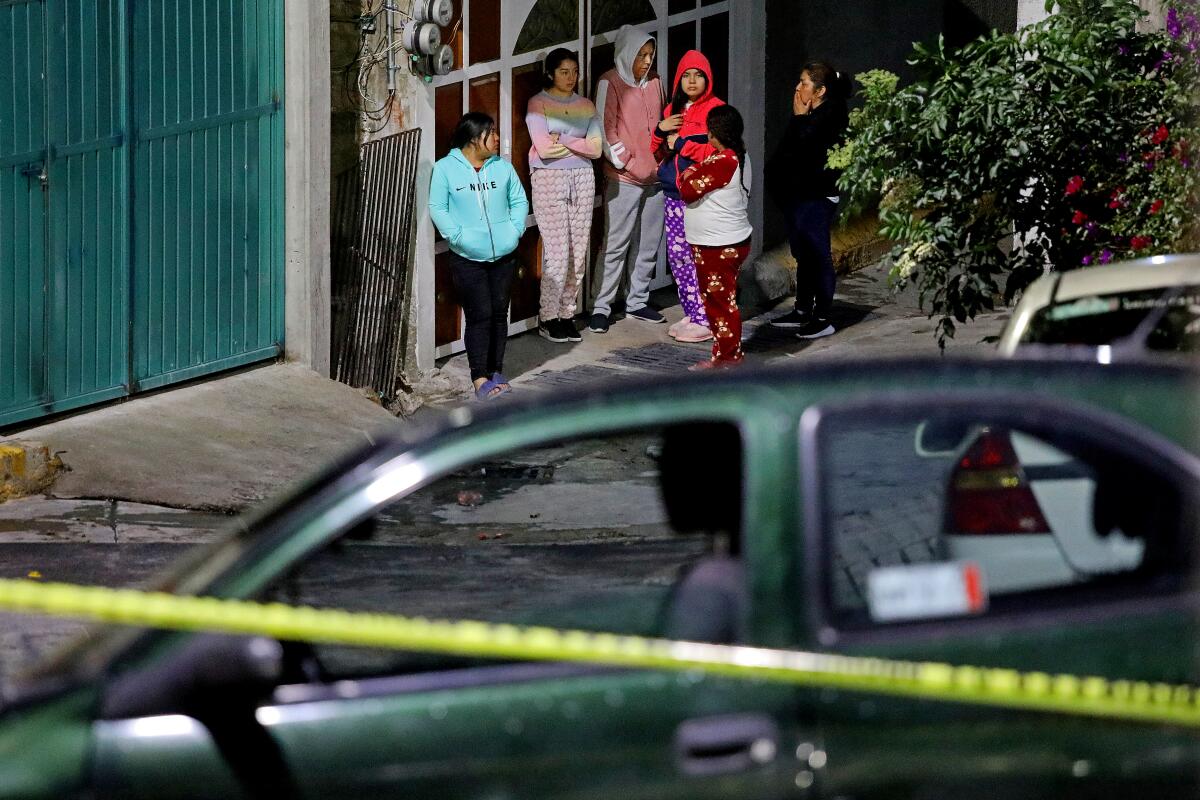 People gather while Mexico City Police officers conduct an investigation where a male 