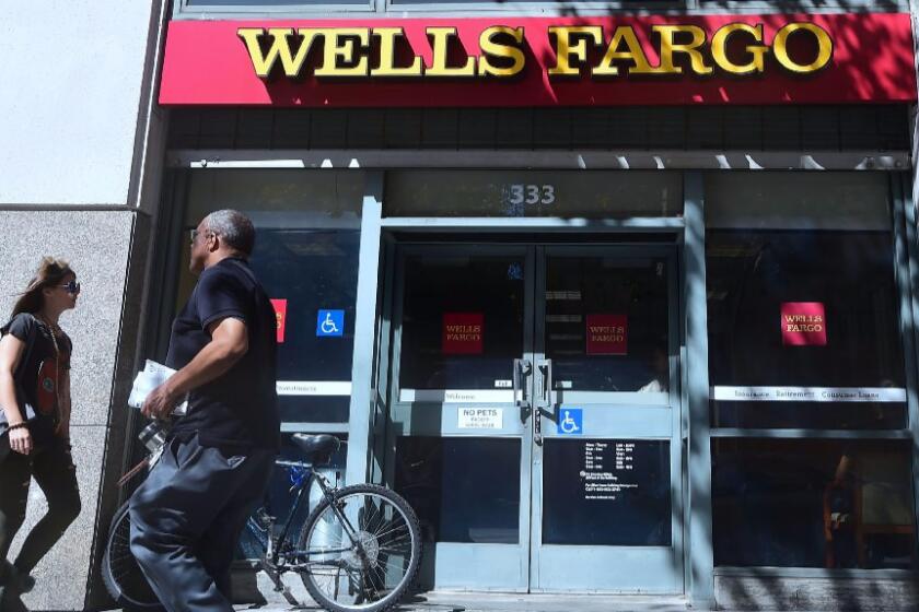 Pedestrians walk past a branch of Wells Fargo bank in downtown Los Angeles on Oct. 3.