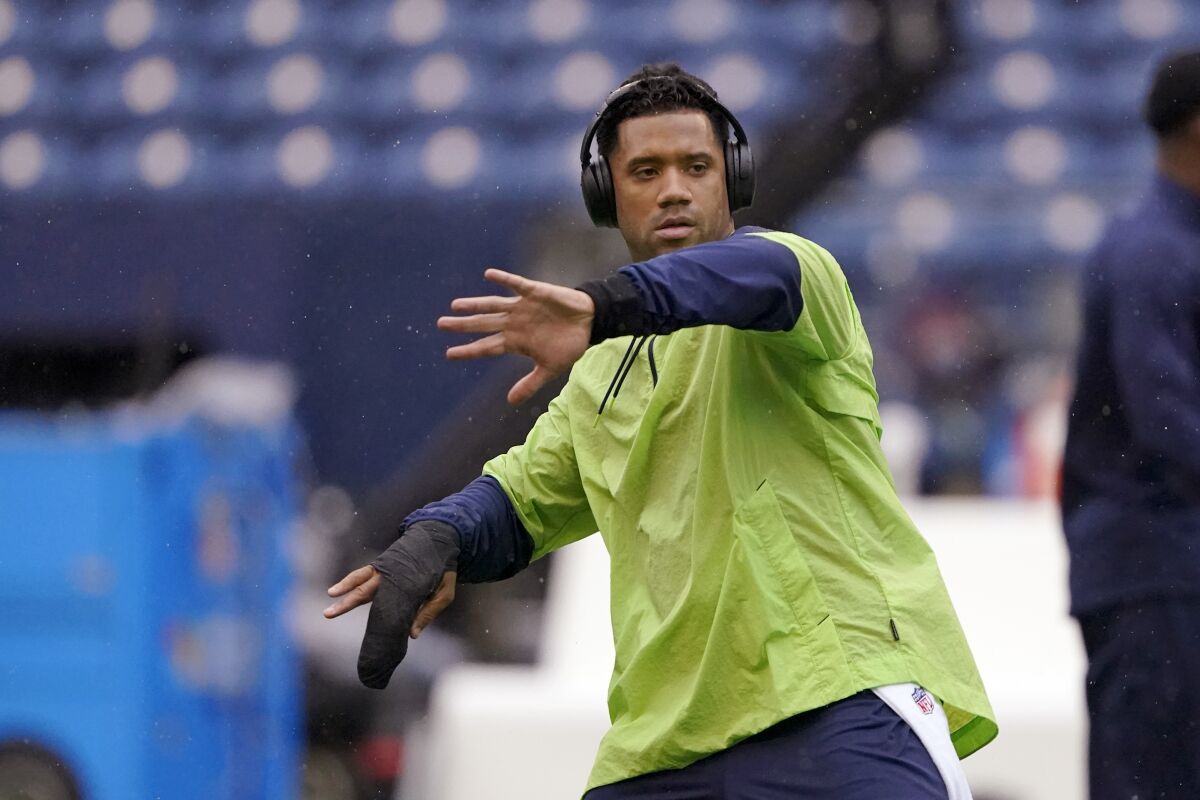 Seattle Seahawks injured quarterback Russell Wilson goes through a throwing motion on the field before an NFL football game against the New Orleans Saints, Monday, Oct. 25, 2021, in Seattle. (AP Photo/Ted S. Warren)