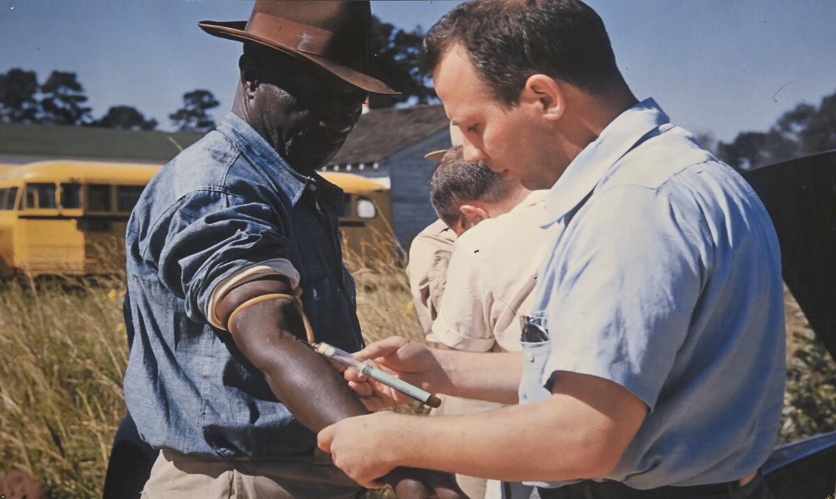 A researcher draws blood from a participant in the Tuskegee syphilis study