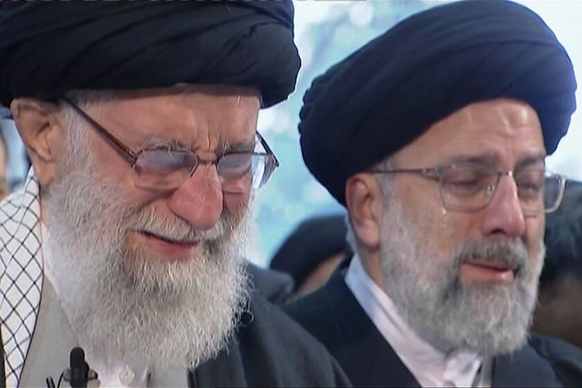 Iranian Supreme Leader Ayatollah Ali Khamenei, left, weeps as he leads a prayer over the coffin of Gen. Qassem Soleimani in Tehran on Monday.