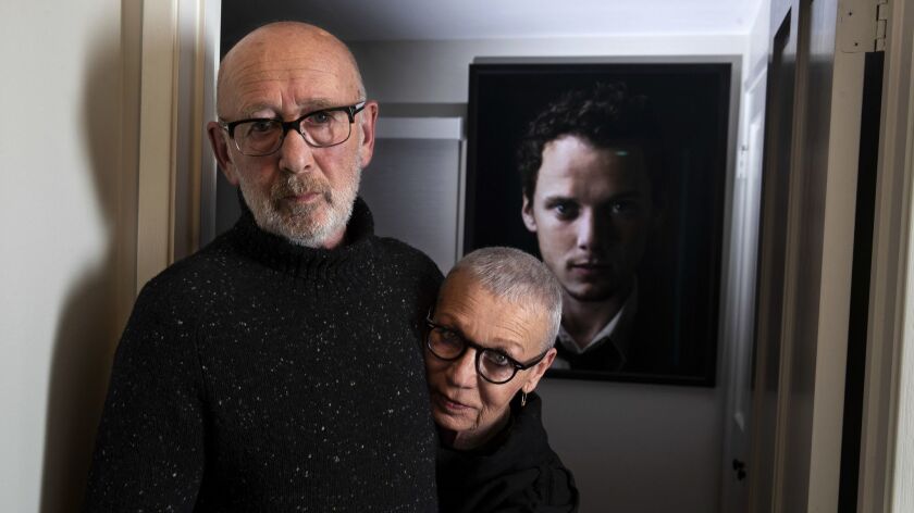 Viktor and Irina Yelchin stand in front of an image of their late son, whose Studio City home they now live in.