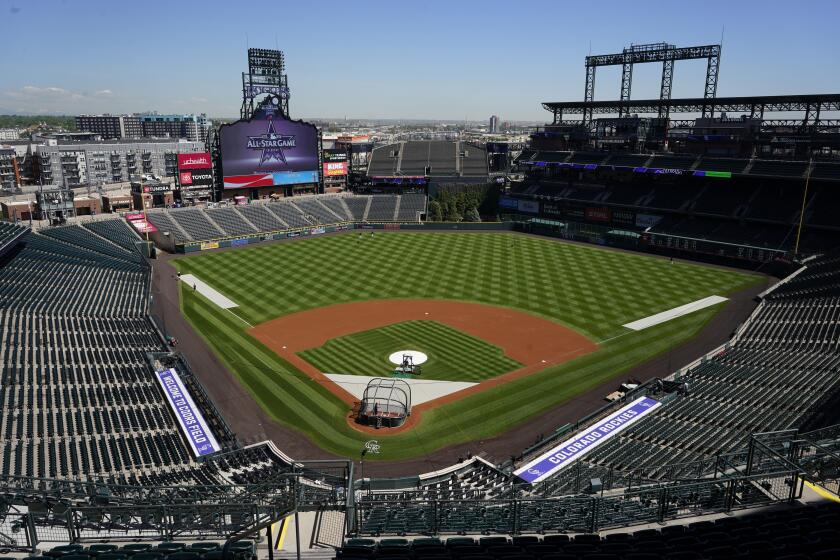 A handful of players warm up before a baseball game in Coors Field as the Colorado Rockies host the Texas Rangers Thursday, June 3, 2021, in Denver. (AP Photo/David Zalubowski)