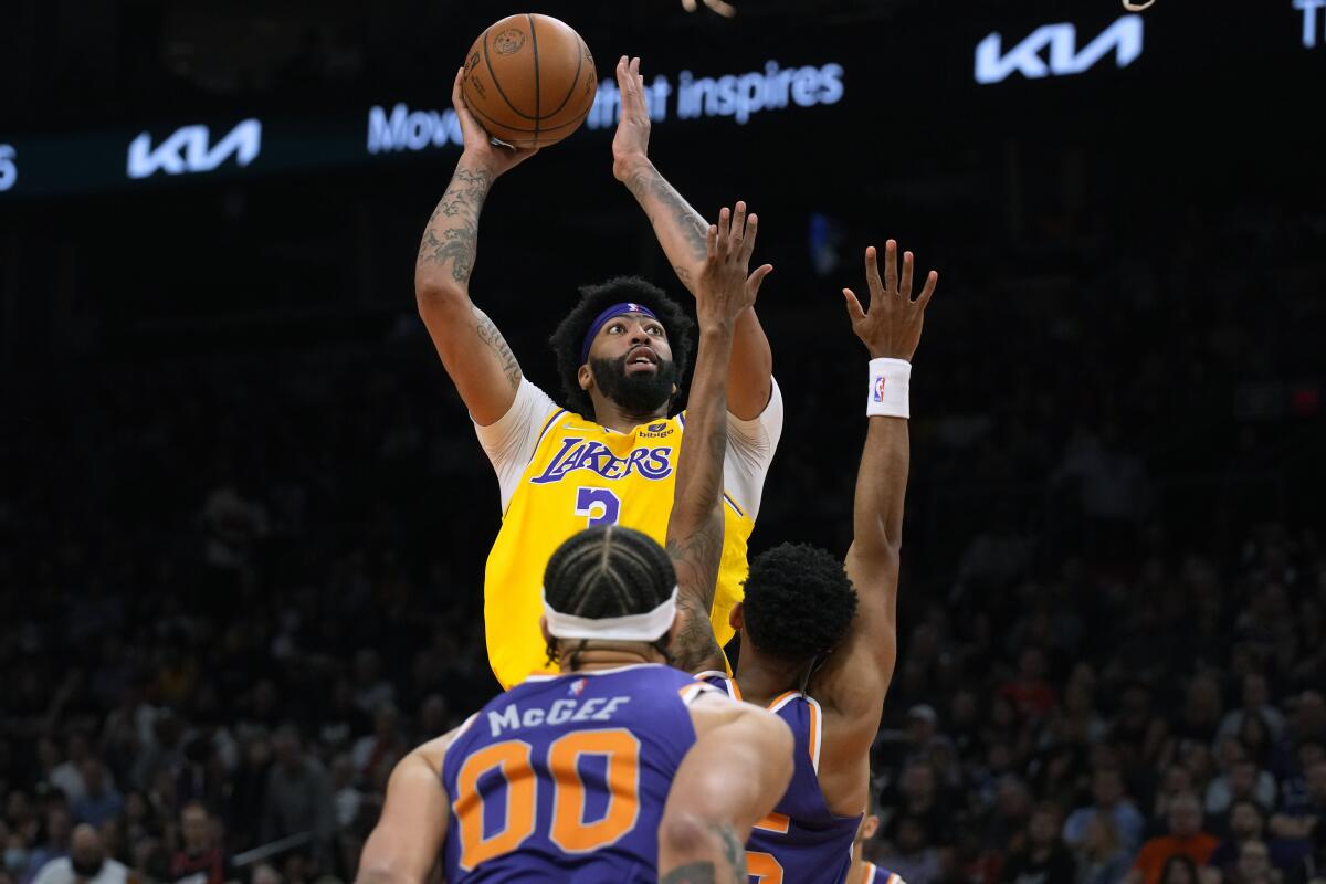 Lakers forward Anthony Davis shoots over Phoenix Suns center JaVale McGee and forward Mikal Bridges.