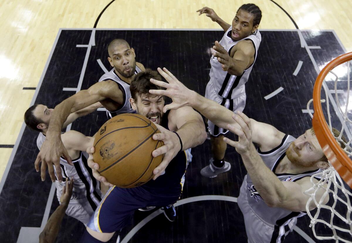 The San Antonio Spurs' defense smothers Memphis Grizzlies big man Marc Gasol in the paint.