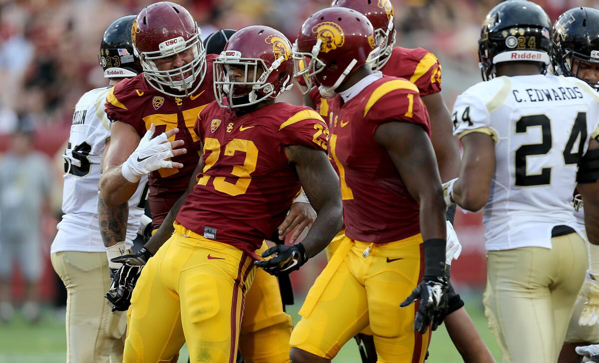Trojans tailback Tre Madden (23) celebrates with teeammates after scoring a touchdown against Idaho in the second quarter Saturday.