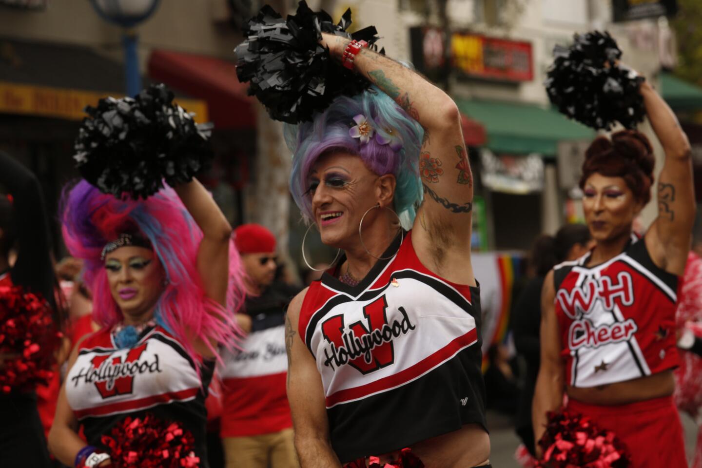 West Hollywood Cheerleaders, from left, Ida Stapedher, Sal Ianniello and Kari Okee march down Santa Monica Boulevard during the gay pride parade in West Hollywood.