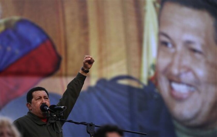 Venezuela's President Hugo Chavez gestures as he delivers a speech in front of the Miraflores Palace during an event commemorating the seventh anniversary of his return to power after a coup that briefly toppled him in 2002, in Caracas, Monday, April 13, 2009. (AP Photo/Ariana Cubillos)