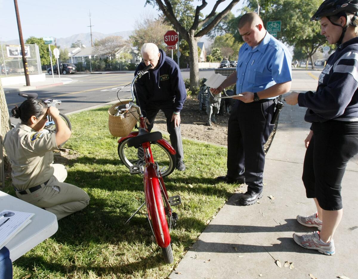 Burbank Police Explorer Brendan Cyr, second from right, helps Kristen Van Dyke, 34 of Burbank, right, register her bicycle during the Burbank Police Department's bike registration event at Chandler Bikeway and Keystone St. in Burbank on Saturday, January 11, 2014.