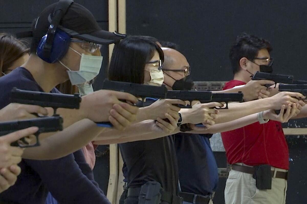 People shoot air soft guns at a private civilian training organization named Polar Light Training in New Taipei City, Taiwan on June 21, 2022. While an invasion doesn’t appear imminent, China's recent large-scale military exercises in response to a visit by U.S. House Speaker Nancy Pelosi to Taiwan have made the government in Taipei more aware than ever of the hard power behind Beijing’s rhetoric about bringing the self-ruled island under its control. Experts said that civilian defense and reserve forces have an important deterrent effect, showing a potential aggressor that the risks of invasion are high. (AP Photo/Wu Taijing)