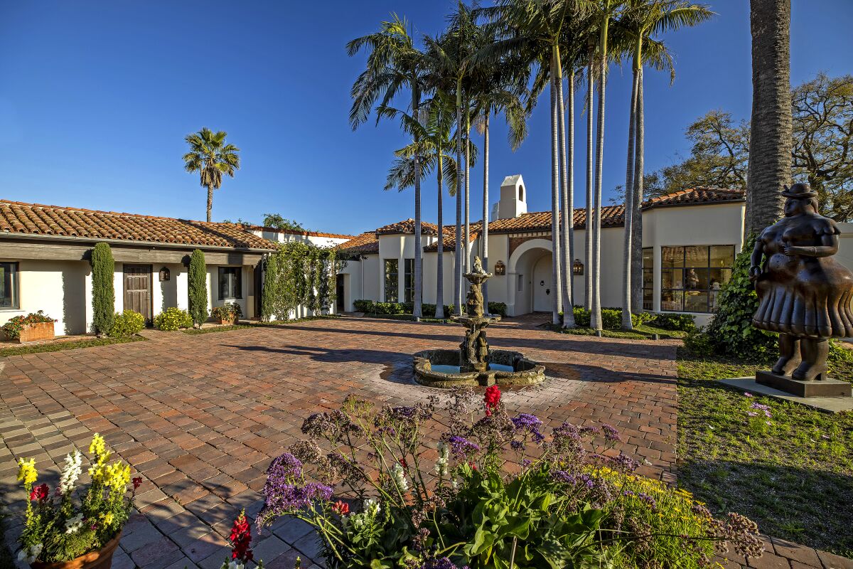 The large flagstone courtyard of the Mediterranean-style mansion includes a fountain.
