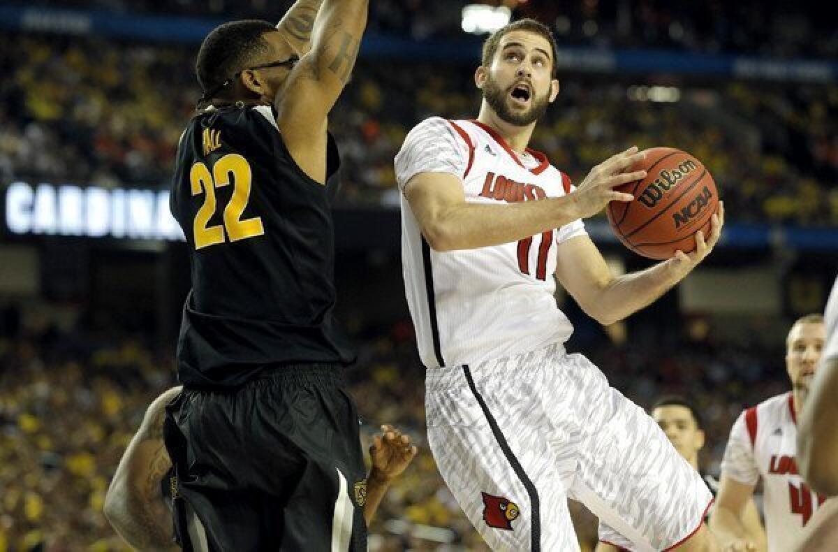 Louisville forward Luke Hancock drives to the basket against Wichita State forward Carl Hall (22) in the second half Saturday night at the Georgia Dome.