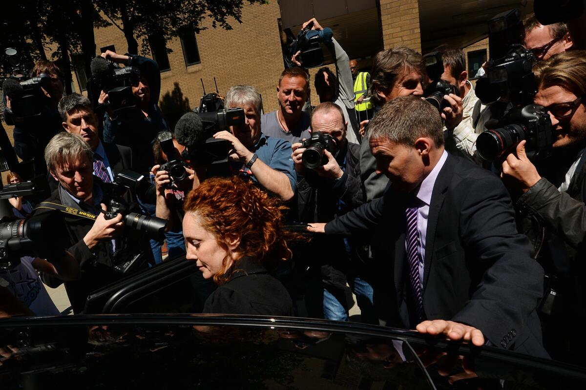 News Corp. said Tuesday that it had not reached a settlement with U.S. officials over a corruption probe. Members of the media surround former News International chief executive Rebekah Brooks, center, as she gets into a car to leave Southwark Crown Court in London on June 5 after attending a hearing in the phone-hacking scandal. Brooks, former chief executive of Rupert Murdoch's British newspaper wing News International, pleaded not guilty on June 5 to charges linked to the phone-hacking scandal.